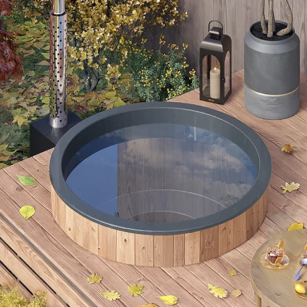 1.8m round hot tub with grey liner and a stove, set on wooden terrace.