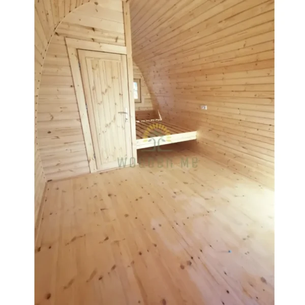 Tilava eristetyn camping-podin sisätila, puiset seinät, sisäänrakennettu sänky ja viihtyisä muotoilu mukavaan asumiseen.