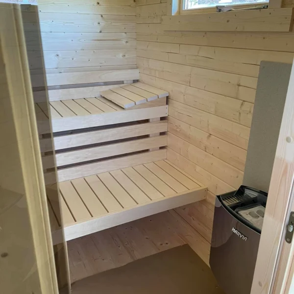 Ahti XL sauna (3.4 x 2.3 m) with 70 mm thick walls and insulated roof elements, designed for Nordic climates. Includes a customizable extra room for a shower or changing area.
