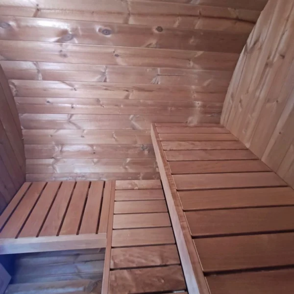 Compact 1.6m barrel sauna with a full glass front wall, perfect for poolside relaxation.