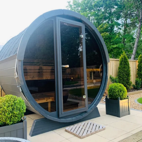 Compact 1.6m barrel sauna with a full glass front wall, perfect for poolside relaxation.