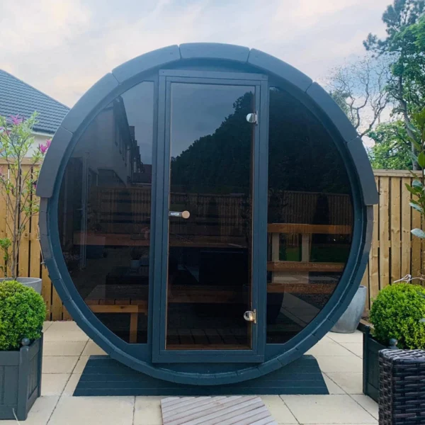 Compact 1.6m barrel sauna with a full glass front wall, perfect for poolside relaxation.