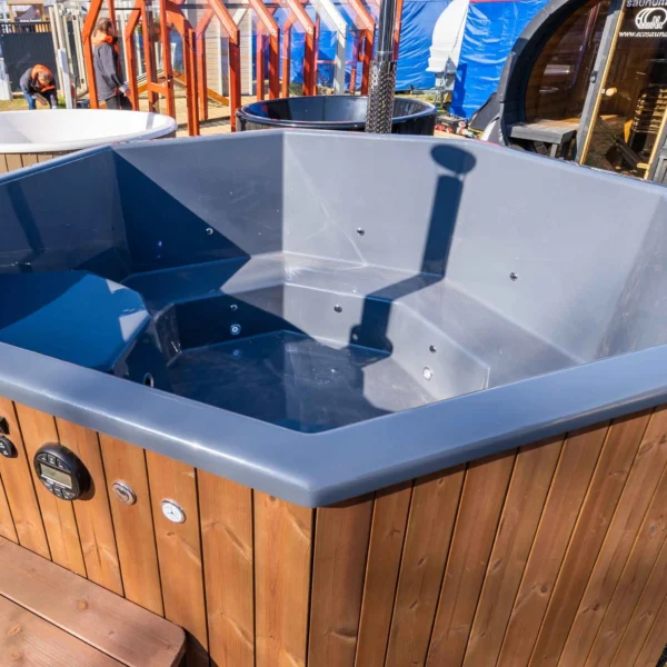 The "BubbleKing XXL" hot tub provides a spacious and luxurious relaxation experience for up to 10 people. It features an ergonomic octagonal fiberglass insert (available in Gray, Blue, or White), durable thermowood walls, and an integrated stainless steel heater (30kW) with a 2-meter chimney. With its 2400-liter capacity, it's perfect for gatherings or quiet evenings. Optional LED lighting, air bubble system, and Bluetooth speakers enhance the experience further.